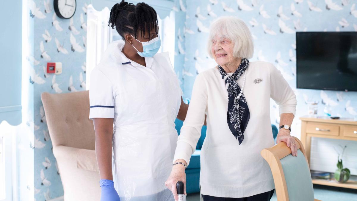 Physio with smiling elderly patient in care home