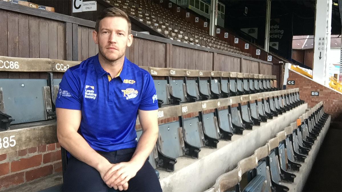 Consultant sports and MSK physio Andy Barker, sitting in a stand at a sports stadium